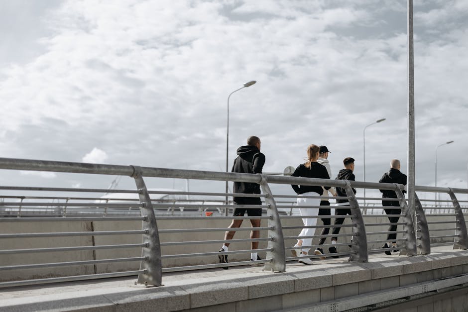 A group of adults jogging on a modern bridge, showcasing healthy lifestyle and exercise