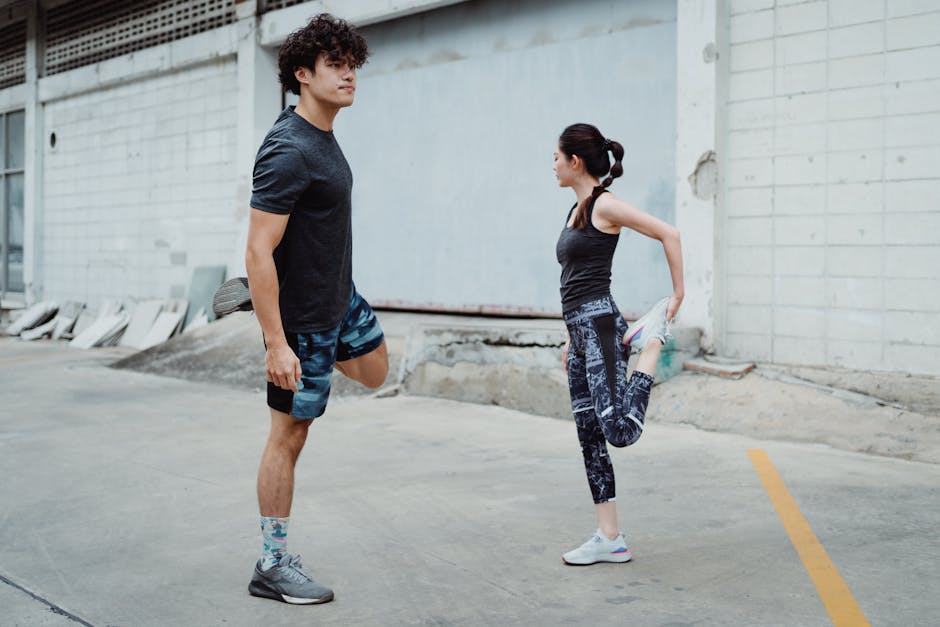Two people stretching outdoors, focusing on balance and fitness in an urban setting